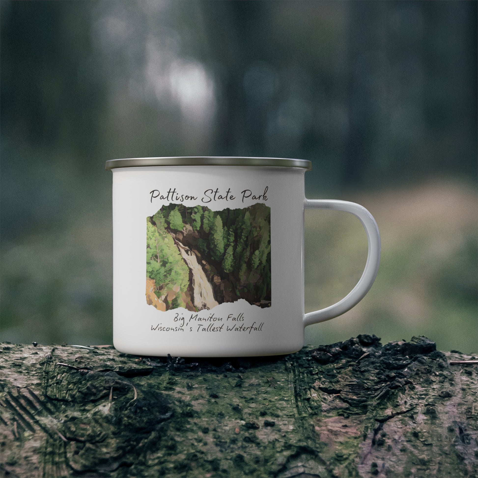 White enamel campfire mug with a CCC style rendering of Big Manitou Falls.  Mug contains the text: Pattison State Park, Big Manitou Fall, Wisconsin’s Tallest Waterfall.  Background of mug sitting on log in woods.