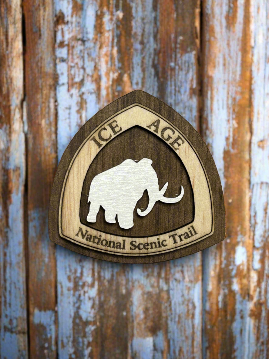 National Trail Icon with Text "Ice Age National Scenic Trail" and a White Mammoth Icon on a walnut colored background. 