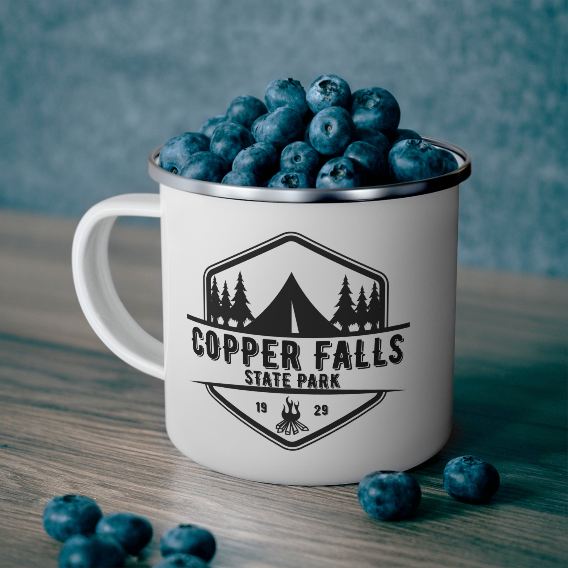 White camper mug depicting a tent and campfire and the wording Copper Falls State Park.