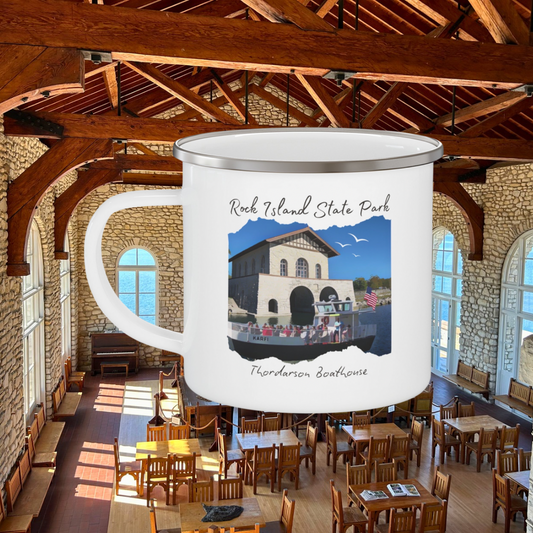 White enamel campfire mug depicting a scene of a ferry boat pulling up to the stone boat house on Rock Island.  Photo background: interior of historic Thordarson boathouse.